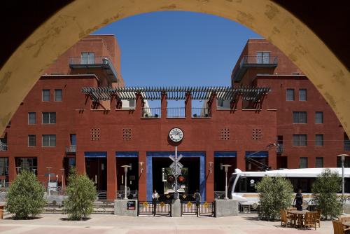 An arch frames an arriving Gold Line train at Del Mar Station.
